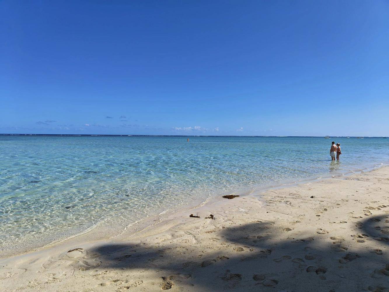 Couple marchant dans l'eau calme d'une plage à Maurice