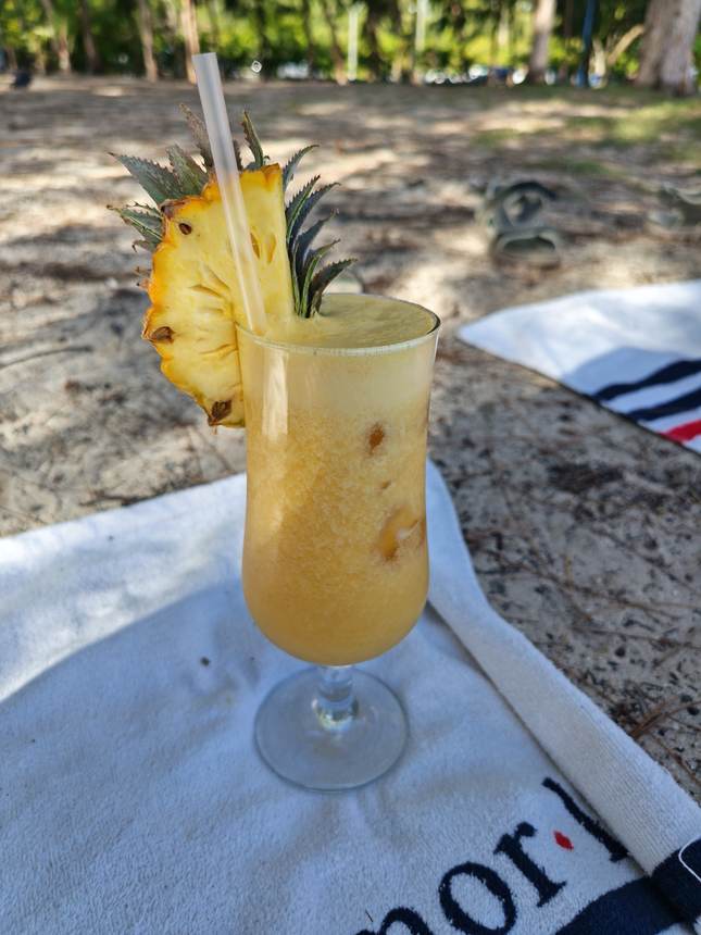 Un cocktail à l’ananas, les pieds dans le sable